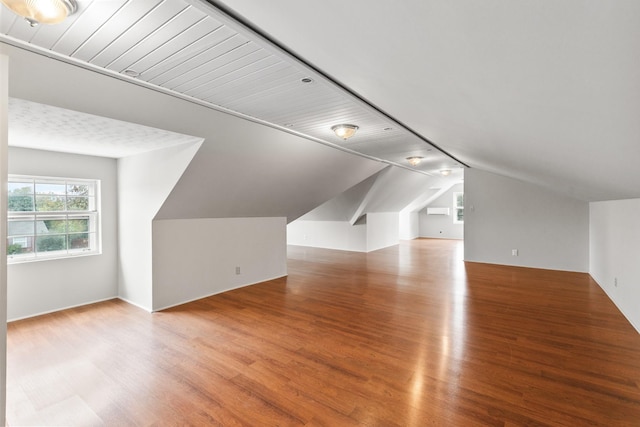 bonus room with lofted ceiling and wood finished floors