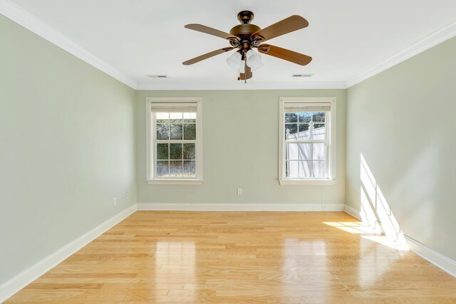 spare room with a healthy amount of sunlight, visible vents, and crown molding