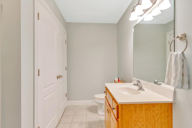 bathroom featuring toilet, tile patterned flooring, vanity, and baseboards