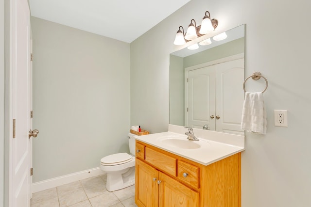 bathroom featuring toilet, tile patterned flooring, baseboards, and vanity