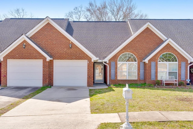 view of front facade featuring a garage, concrete driveway, a front lawn, and roof with shingles