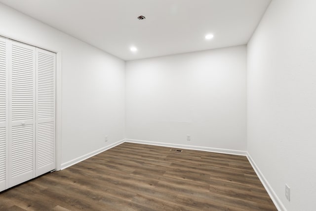 unfurnished bedroom featuring a closet, recessed lighting, wood finished floors, and baseboards