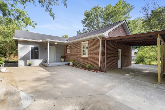 single story home with an attached carport, concrete driveway, and brick siding