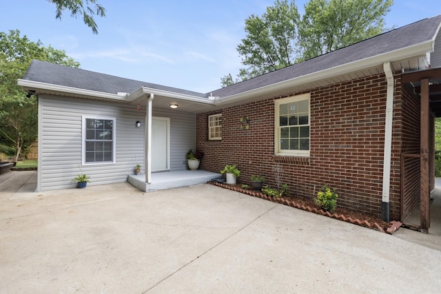 rear view of property featuring brick siding and a patio