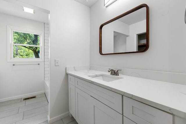 bathroom featuring baseboards, a tub, tile patterned floors, walk in shower, and vanity