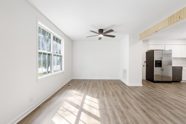 unfurnished living room featuring light wood-type flooring, baseboards, visible vents, and ceiling fan