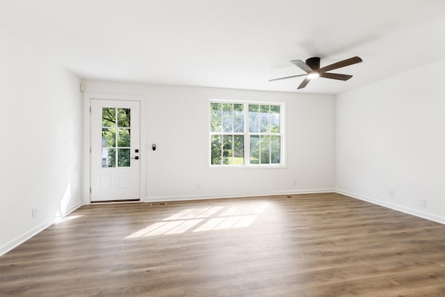 interior space featuring baseboards, wood finished floors, and a healthy amount of sunlight