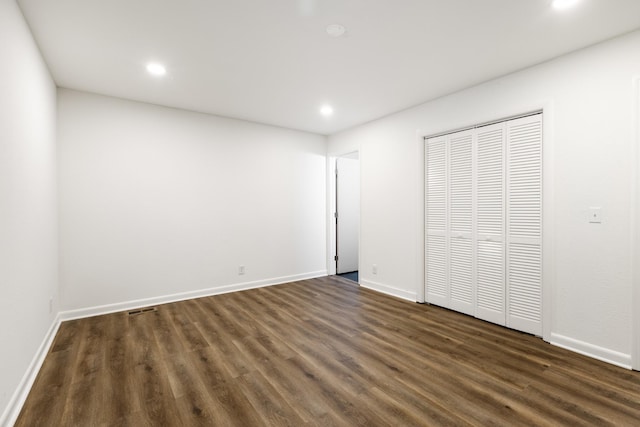 unfurnished bedroom with visible vents, baseboards, dark wood-type flooring, a closet, and recessed lighting