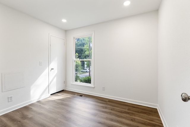 empty room with baseboards, visible vents, wood finished floors, and recessed lighting