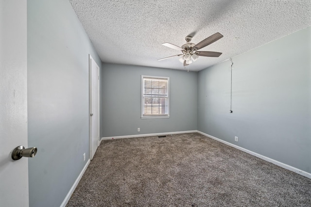 carpeted spare room featuring ceiling fan, baseboards, and a textured ceiling