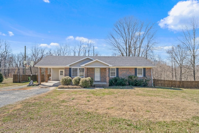 single story home with a front yard, brick siding, fence, and driveway