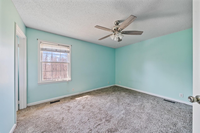 spare room featuring ceiling fan, carpet, visible vents, and baseboards