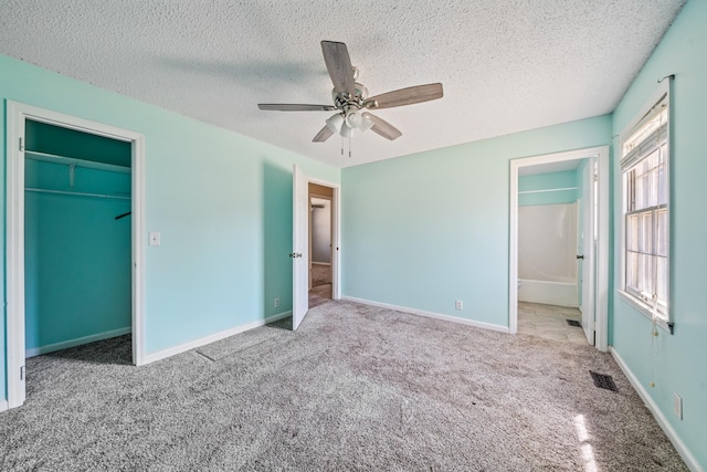 unfurnished bedroom featuring a textured ceiling, carpet, visible vents, and baseboards