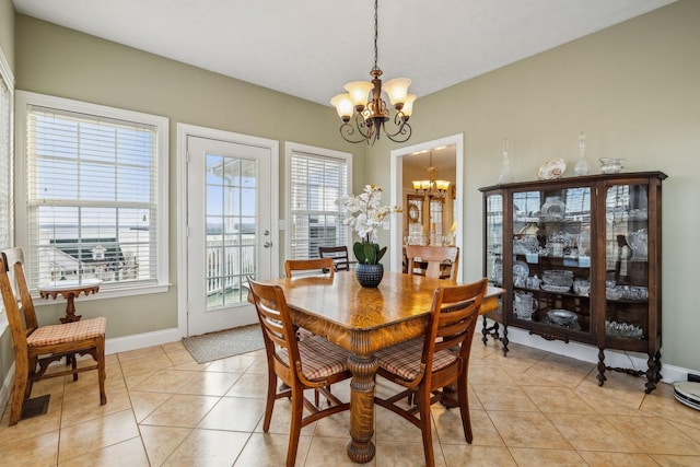 dining room with light tile patterned floors, baseboards, and an inviting chandelier