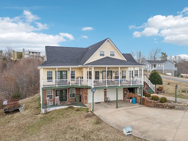 view of front of home with roof with shingles, concrete driveway, covered porch, an attached garage, and stairs