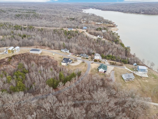 drone / aerial view featuring a water view and a wooded view