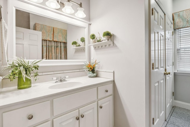 bathroom featuring tile patterned floors, vanity, and baseboards