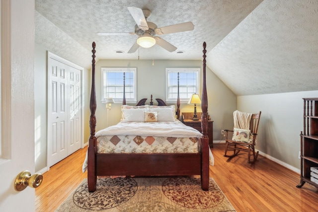 bedroom featuring a textured ceiling, wood finished floors, visible vents, and lofted ceiling