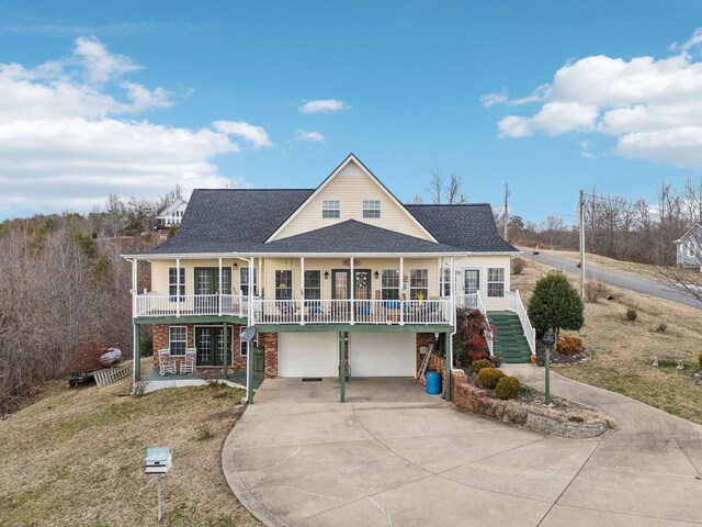 view of front of house with covered porch, a garage, stairs, driveway, and roof with shingles