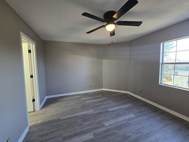 empty room featuring ceiling fan, baseboards, and wood finished floors