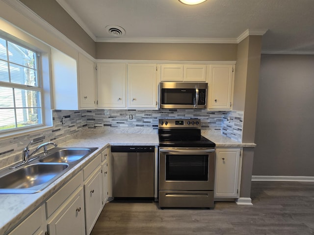 kitchen with stainless steel appliances, dark wood finished floors, white cabinetry, and a sink