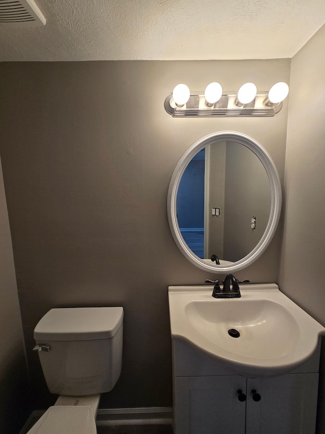 bathroom with visible vents, a textured ceiling, toilet, and vanity