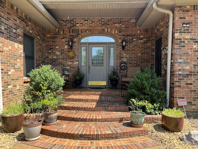 view of exterior entry featuring brick siding