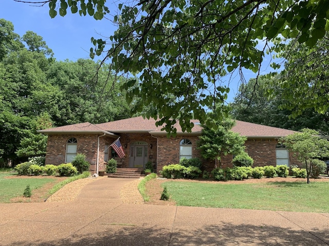 single story home featuring brick siding and a front lawn