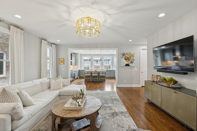 living area featuring an inviting chandelier, baseboards, dark wood finished floors, and recessed lighting