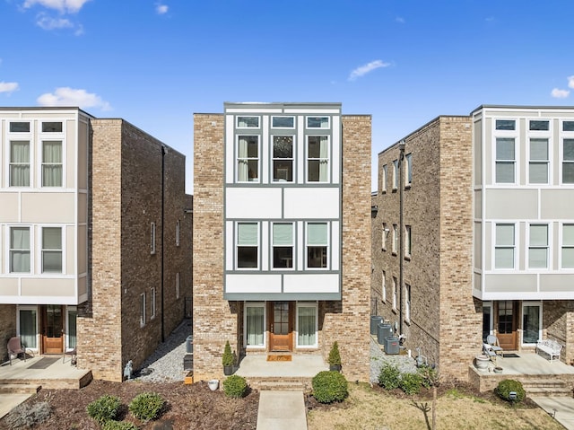 view of front of property featuring a patio and brick siding