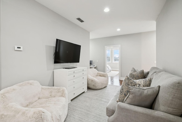 living room with baseboards, visible vents, and recessed lighting