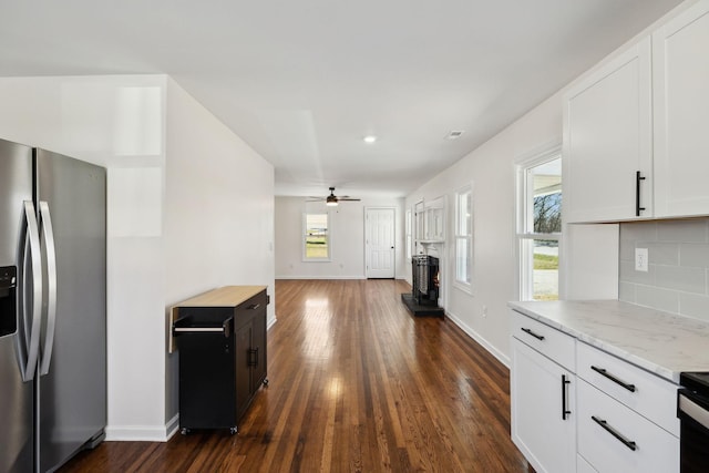 kitchen featuring decorative backsplash, ceiling fan, dark wood-type flooring, white cabinetry, and stainless steel refrigerator with ice dispenser