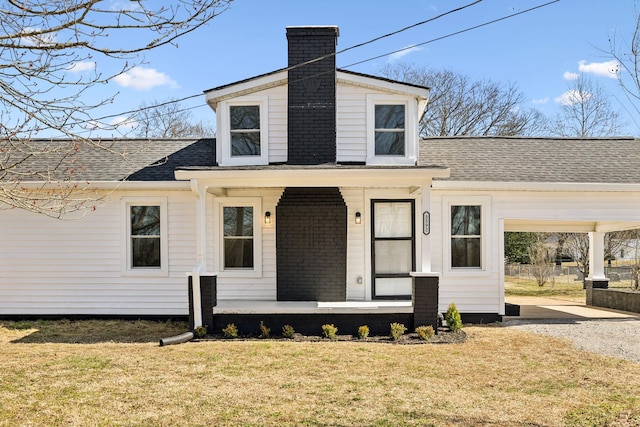 view of front of property featuring covered porch, a shingled roof, a chimney, and a front lawn