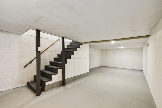 finished basement with concrete block wall and stairs