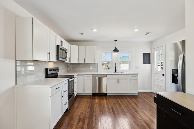 kitchen featuring dark wood-style flooring, light countertops, decorative backsplash, appliances with stainless steel finishes, and a sink