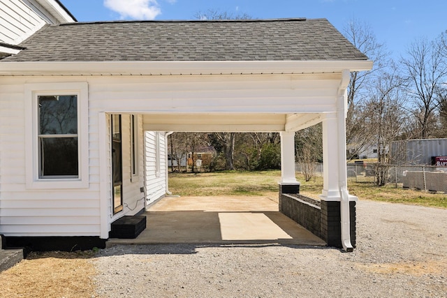 view of patio featuring gravel driveway and fence