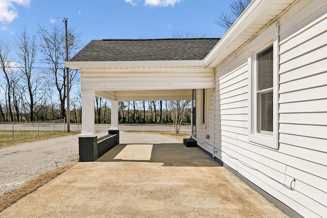 view of patio with concrete driveway and fence