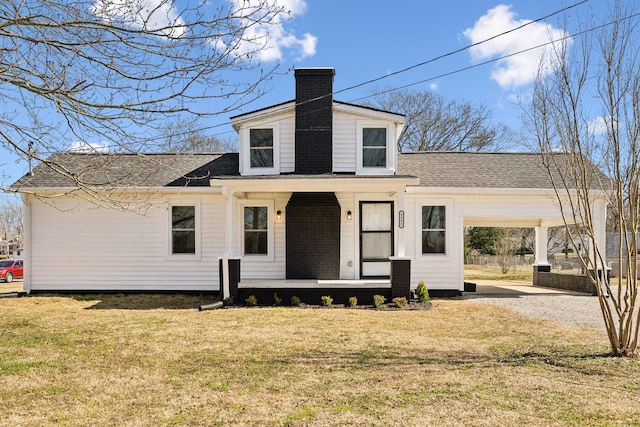 view of front of house with covered porch, roof with shingles, a front lawn, a chimney, and gravel driveway