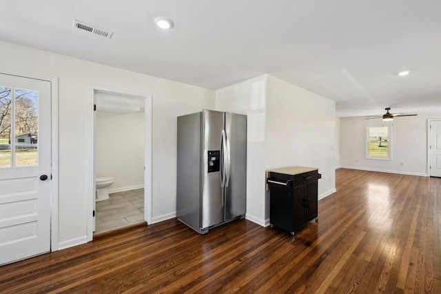 kitchen featuring a ceiling fan, visible vents, baseboards, dark wood-style floors, and stainless steel fridge