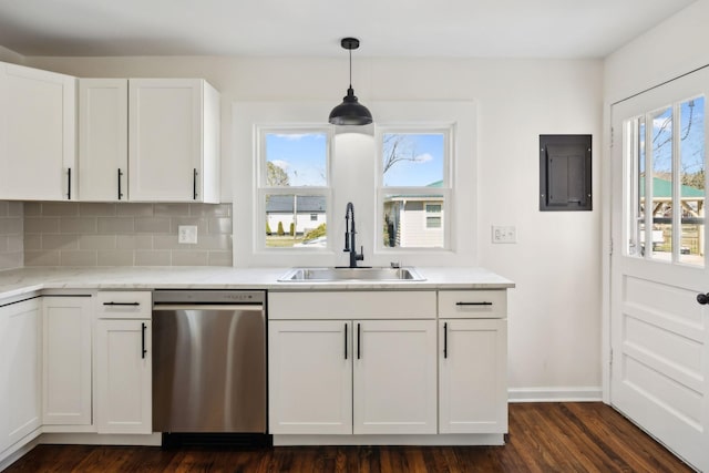 kitchen with light countertops, decorative backsplash, stainless steel dishwasher, white cabinets, and a sink