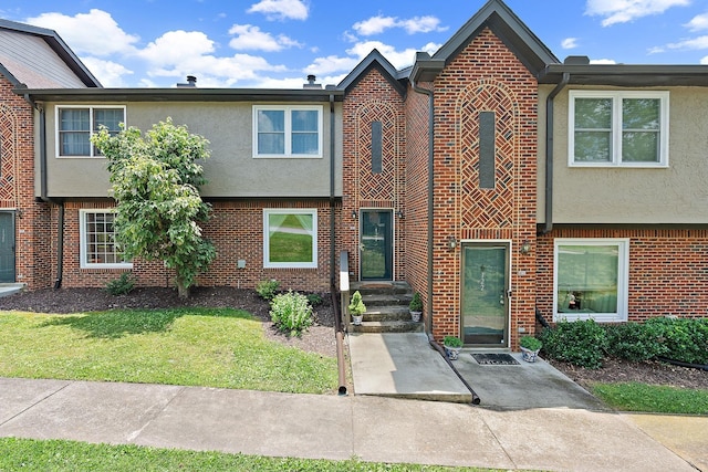 townhome / multi-family property with brick siding and stucco siding