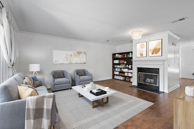 living room featuring crown molding, a glass covered fireplace, dark wood finished floors, and baseboards