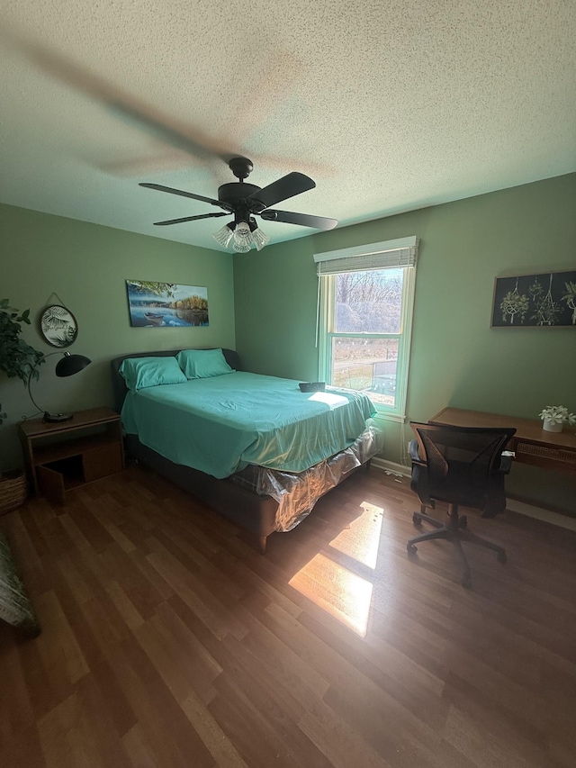 bedroom featuring a textured ceiling, a ceiling fan, and wood finished floors