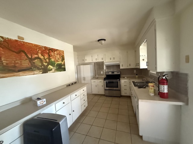 kitchen with decorative backsplash, light countertops, white cabinetry, and stainless steel electric range