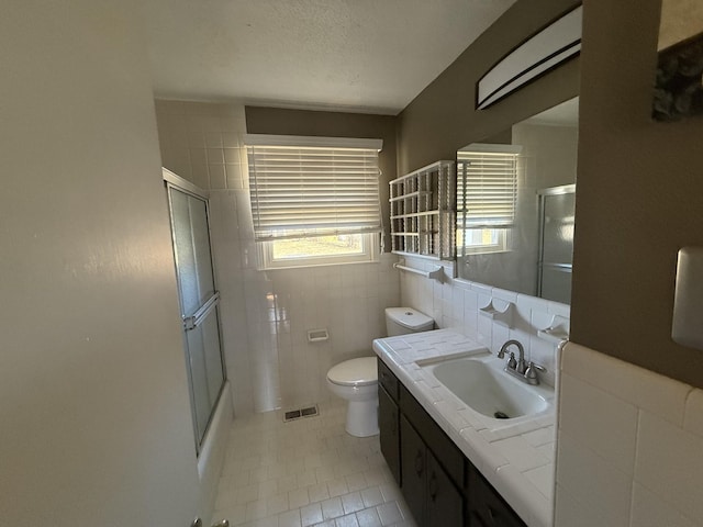 full bathroom with tile patterned floors, a shower stall, visible vents, and tile walls