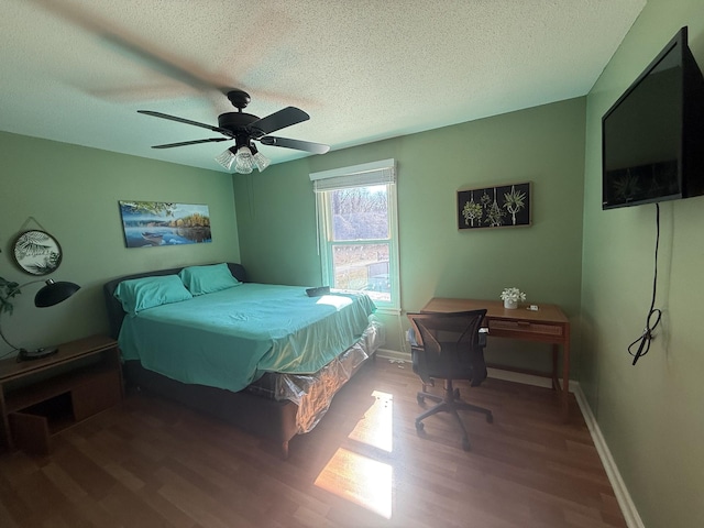 bedroom featuring a ceiling fan, a textured ceiling, baseboards, and wood finished floors