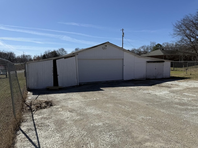 detached garage featuring fence