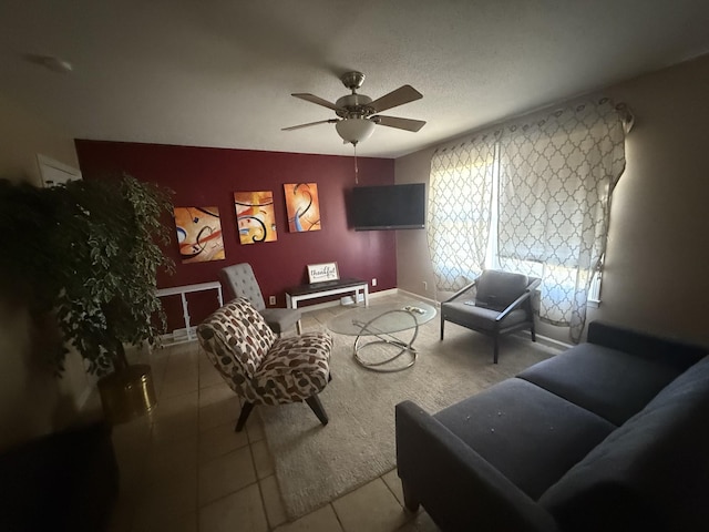 living room featuring ceiling fan, a textured ceiling, and tile patterned floors