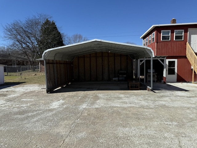 exterior space featuring a detached carport, driveway, and fence