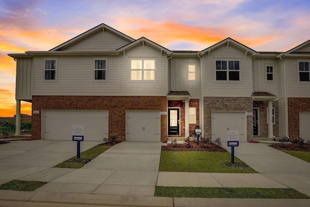 view of front of property with a garage, concrete driveway, and brick siding